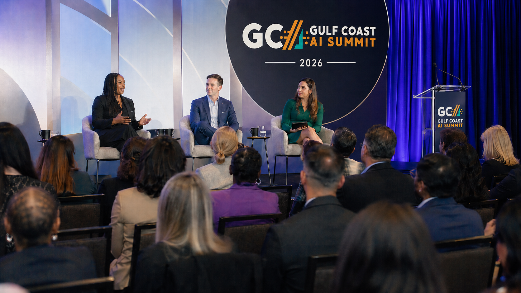 Panel discussion on stage at the Gulf Coast AI Summit with attendees in the audience
